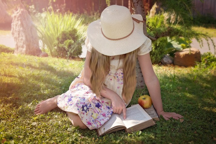 woman with hat reading a book